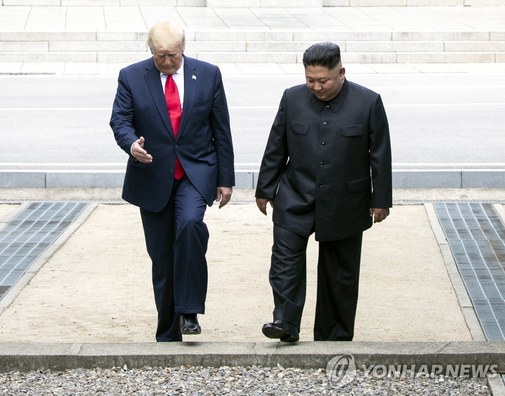 In the file photo, taken June 30, 2019, U.S. President Donald Trump and North Korean leader Kim Jong-un are seen crossing the Korean military demarcation lines to South Korea after holding a brief meeting on the North Korean side of the border that divides the two Koreas. The meeting at the truce village of Panmunjom marked the leaders' third meeting that followed their two bilateral summits in June 2018 and February 2019. (Yonhap)