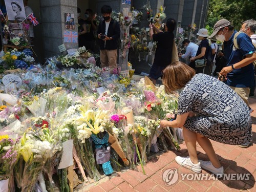 [촬영 윤고은]엘리자베스 2세 영국 여왕을 추모하기 위해 13일 홍콩 주재 영국 총영사관 앞에 모여든 추모객과 그들이 놓고 간 꽃들.