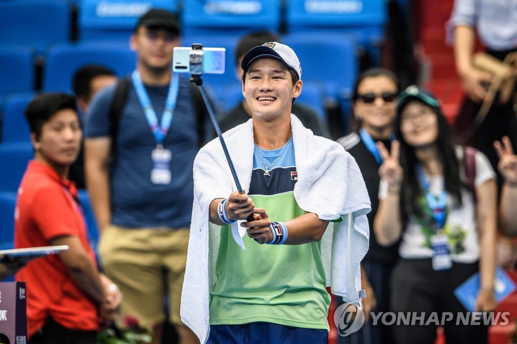 In this AFP photo, Kwon Soon-woo of South Korea takes a selfie with fans after beating Lucas Pouille of France in the men's singles first-round match at the Huajin Securities Zhuhai Championships in Zhuhai, China, on Sept. 25, 2019. (Yonhap)