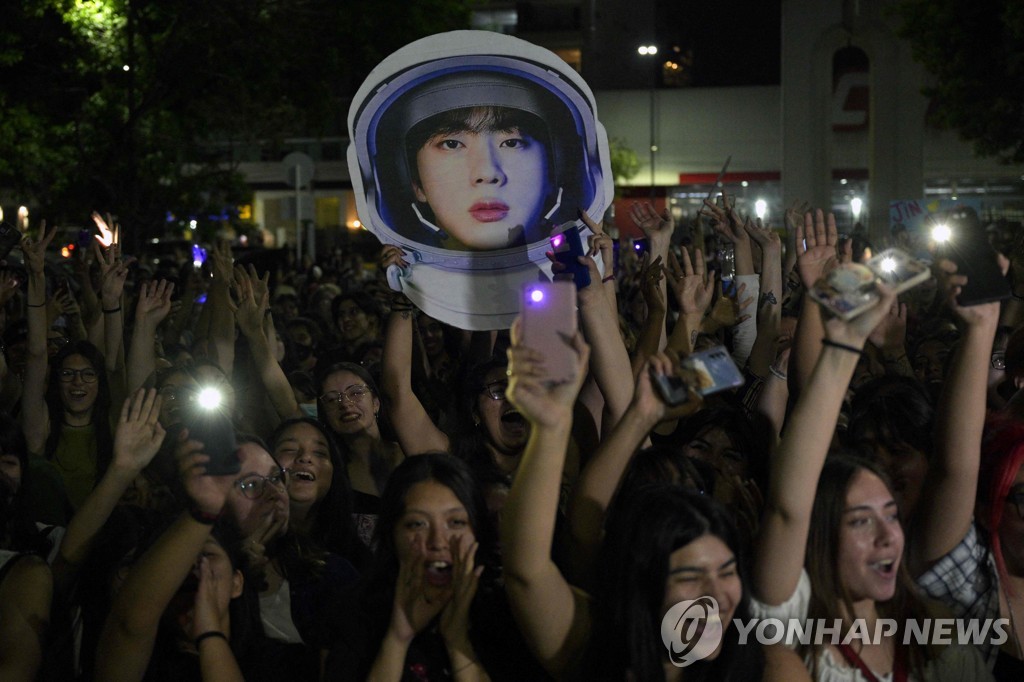 Fans of K-pop boy band BTS wait to attend a concert of the British rock band Coldplay in Buenos Aires on Oct. 28, 2022, in this AFP photo. Jin, a BTS member, performed his first solo single "The Astronaut" with the band during the show. (Yonhap)
