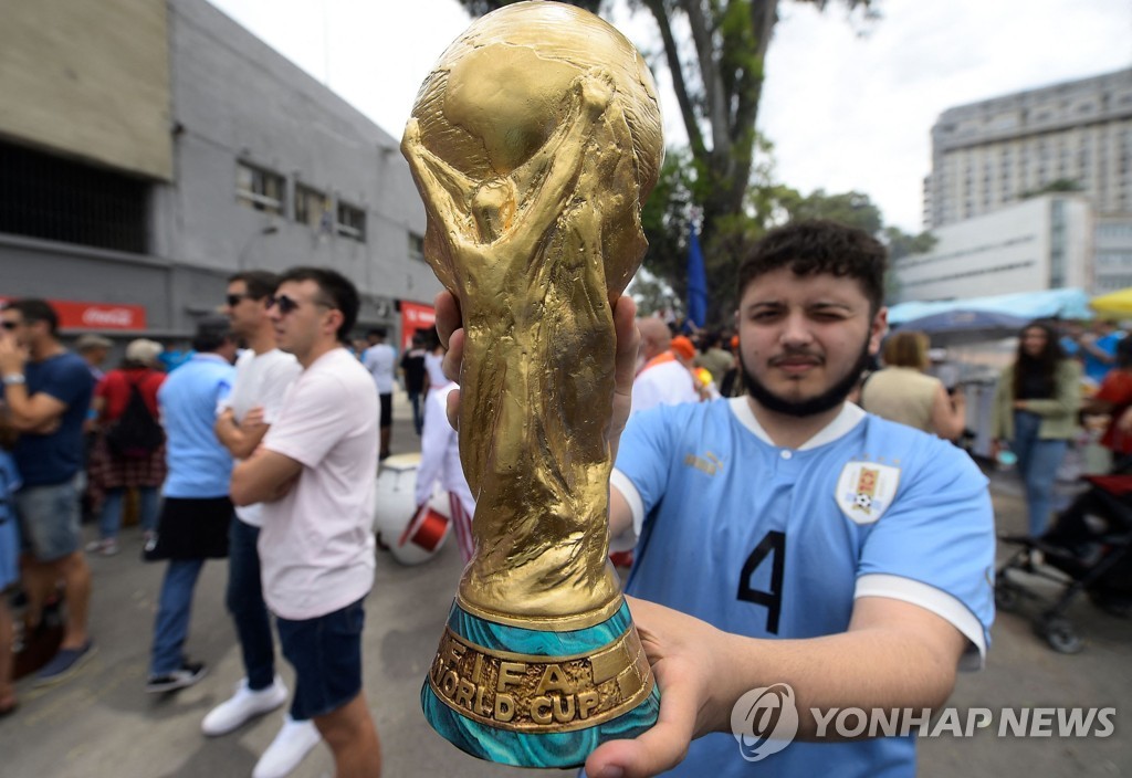 월드컵 우승 트로피 모조품을 들어 보이는 우루과이 팬.