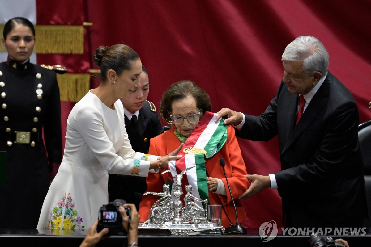 지난 1일(현지시간) 멕시코 대통령 취임식에서 어깨띠 건네주는 이피헤니아 마르티네스 하원 의장(가운데) 