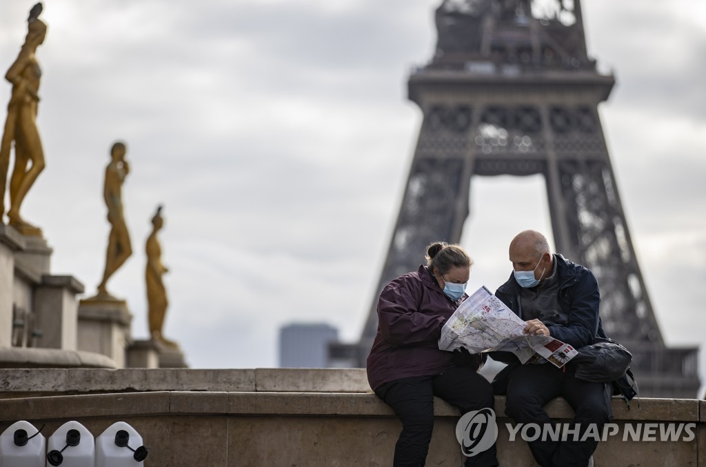 (파리 EPA=연합뉴스) 5일(현지시간) 프랑스 파리 에펠 타워 인근에서 두 사람이 마스크를 쓰고 지도를 보고 있다. 2021.11.5. photo@yna.co.kr