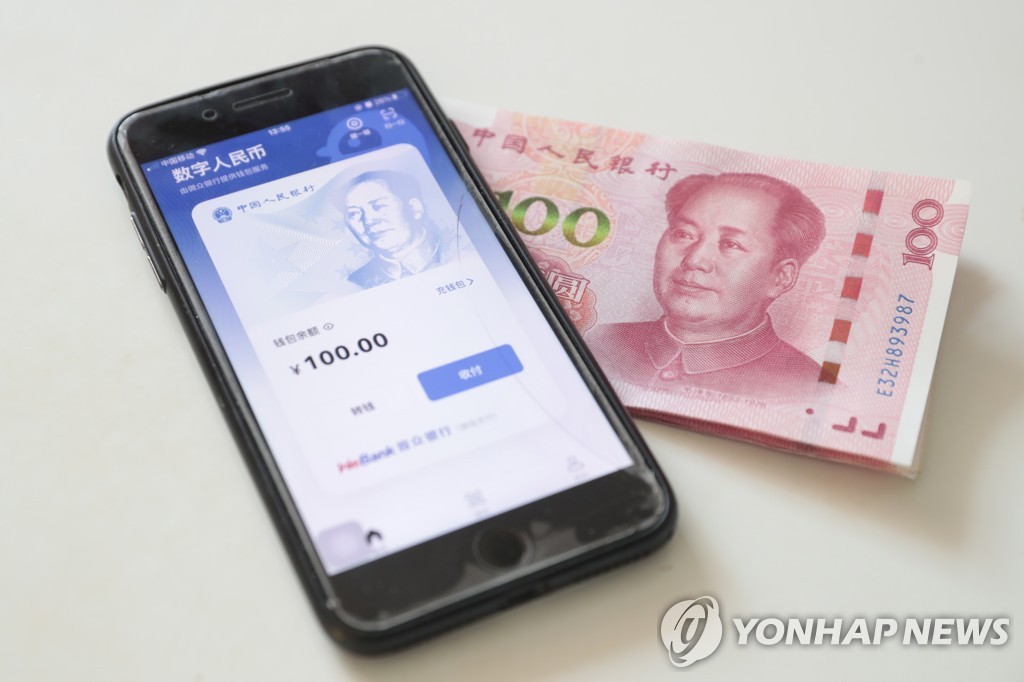 휴대전화 속 중국 디지털위안 지갑 화면 및 100위안 지폐