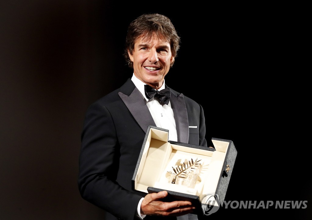 In this EPA photo, Hollywood actor Tom Cruise shows off an honorary Palme d'Or award before the screening of "Top Gun: Maverick" during the 75th Cannes Film Festival in Cannes, France, on May 18, 2022. (Yonhap)
