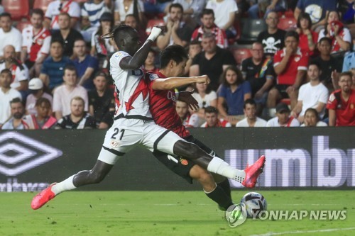 In this EPA photo, Lee Kang-in of RCD Mallorca (R) scores past Pathe Ciss of Rayo Vallecano during the clubs' La Liga match at Estadio de Vallecas in Madrid on Aug. 27, 2022. (Yonhap)