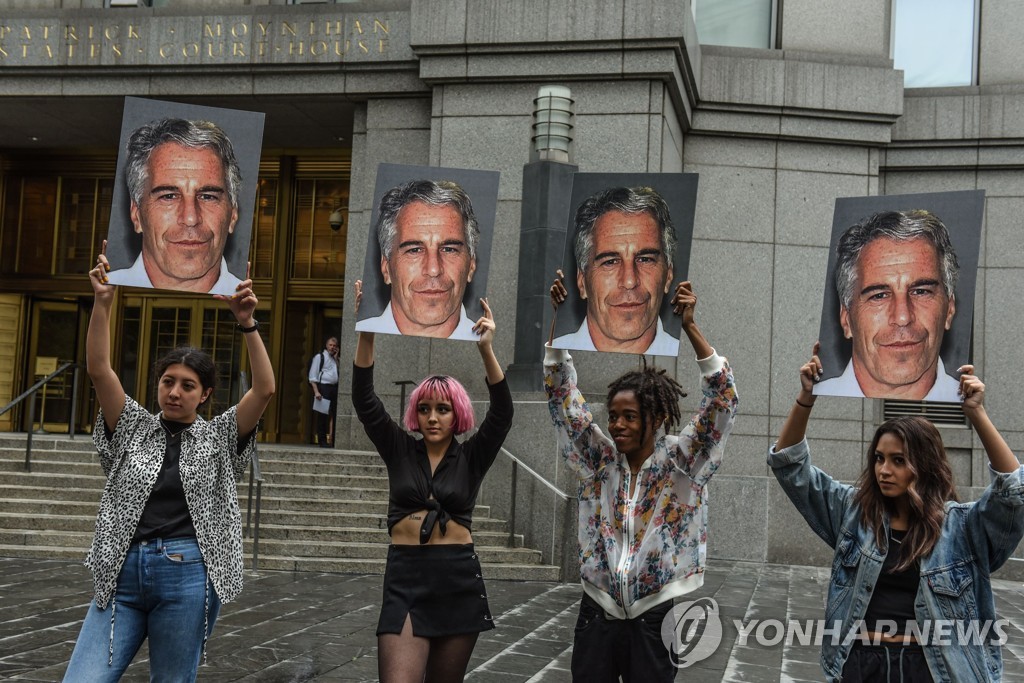 (뉴욕 AFP=연합뉴스) 제프리 엡스타인의 사진을 든 시위대가 현지시간 8일 미국 뉴욕 법원 앞에 서 있다.[게티 이미지 제공]