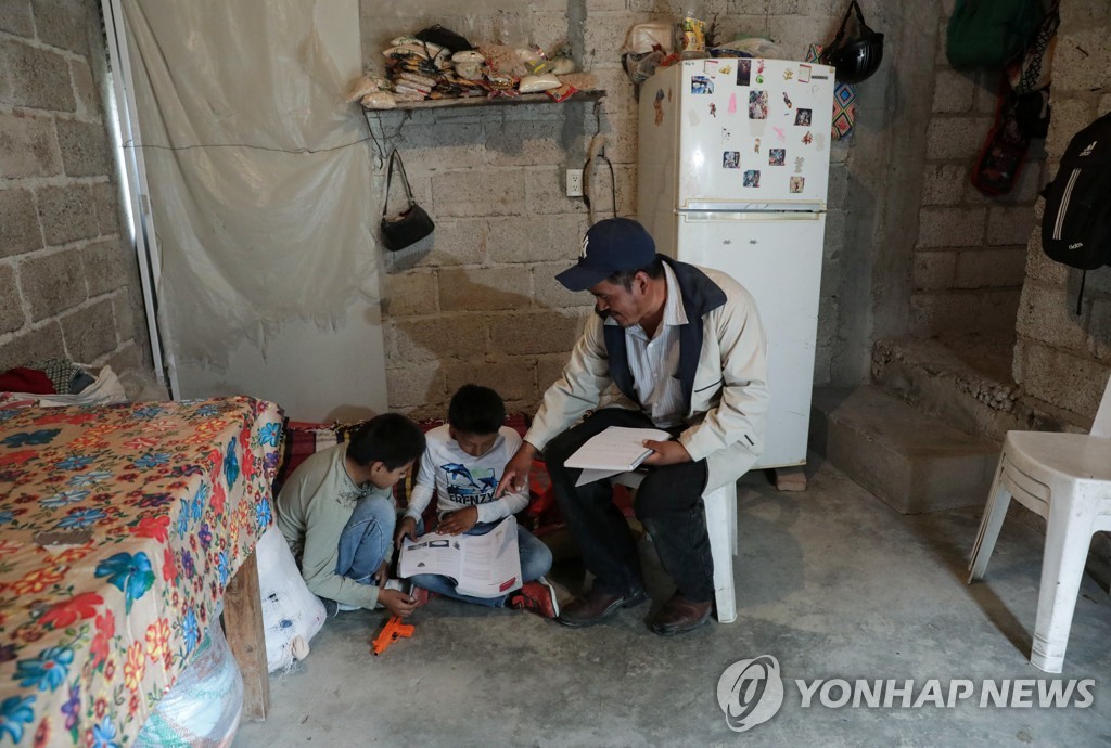 TV 수업 후 자녀들의 공부를 도와주는 멕시코 남성