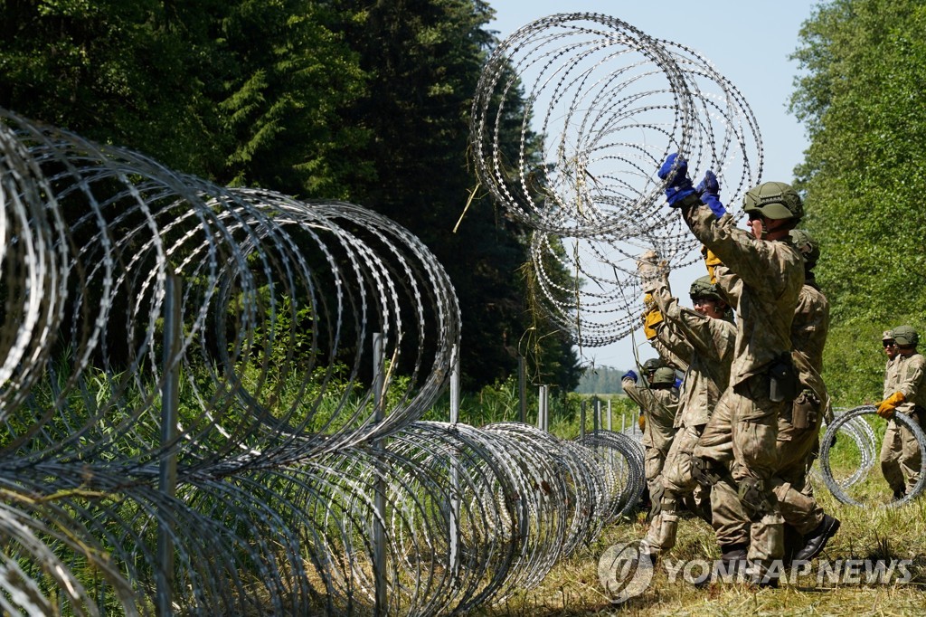 지난달 9일(현지시간) 리투아니아 군인들이 자국의 벨라루스 접경 지역에 철선을 설치하고 있다. [로이터=연합뉴스 자료사진]