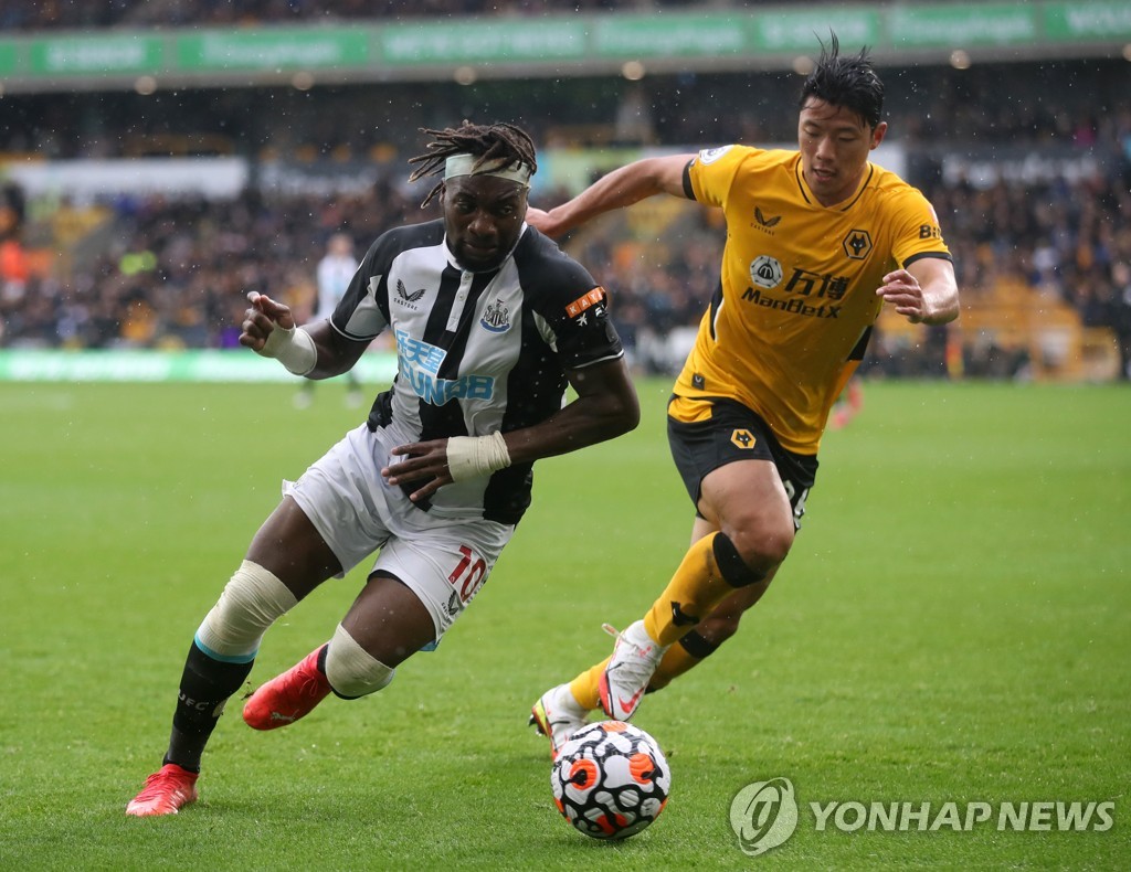 In this Reuters photo, Hwang Hee-chan of Wolverhampton Wanderers (R) battles Allan Saint-Maximin of Newcastle United for the ball during the clubs' Premier League match at Molineux Stadium in Wolverhampton, England, on Oct. 2, 2021. (Yonhap)