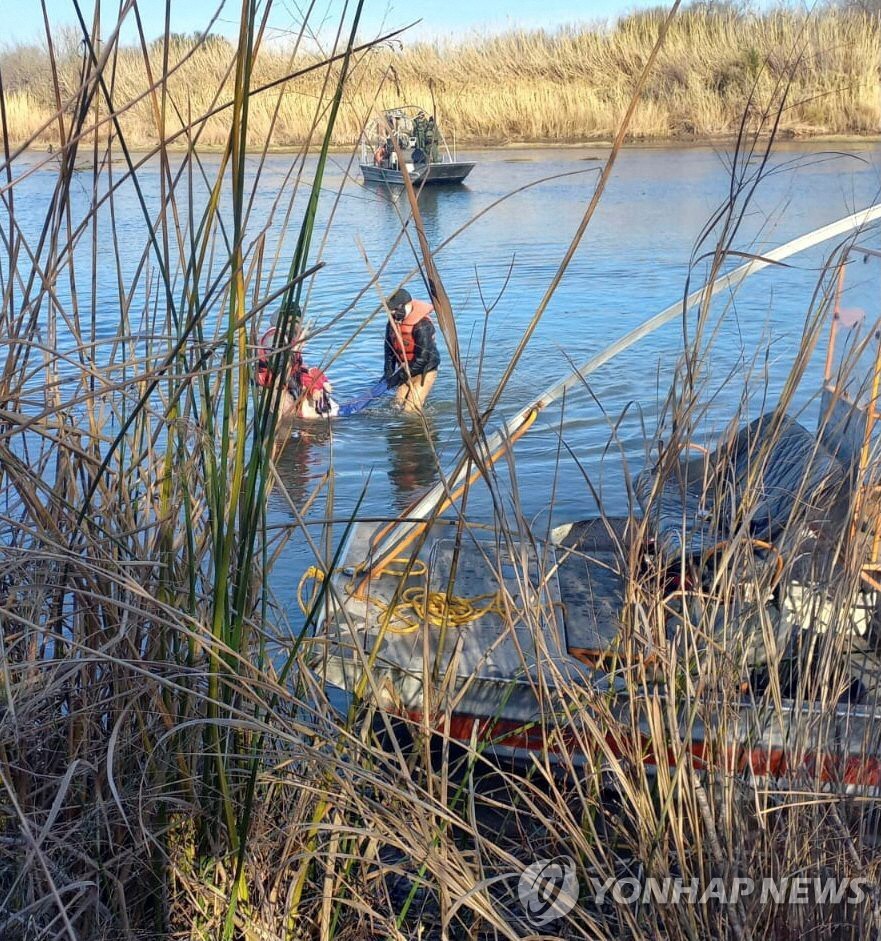멕시코 이민청 요원들이 지난 18일(현지시간) 미국과의 국경 강에서 빅토리아의 시신을 수습하고 있다.