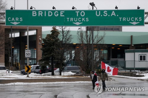 봉쇄된 앰버서더 다리 앞을 지나는 캐나다 시위대 참가자
