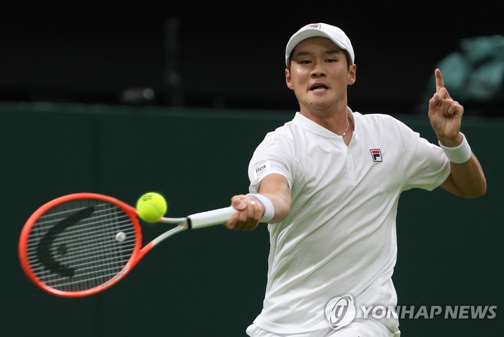 In this Reuters photo, Kwon Soon-woo of South Korea hits a shot against Novak Djokovic of Serbia during their men's singles first round match at Wimbledon at All England Club in London on June 27, 2022. (Yonhap)