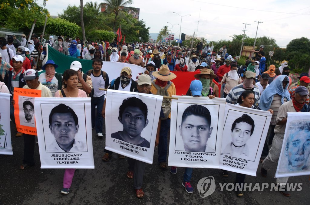 실종 대학생 43명의 사진을 앞세운 멕시코 시위대가 10일(현지시간) 게레로주(州) 아카풀코 국제공항 진입로를 점거, 출입을 차단하고 있다. (AP=연합뉴스)