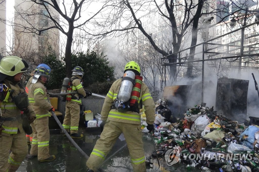 쓰레기 소각 중 발생한 화재를 진압 중인 소방관들