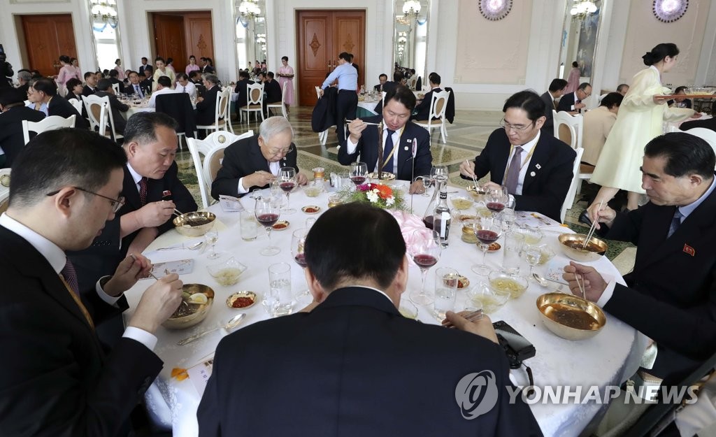 ９月に開かれた南北首脳会談の際、訪朝団として平壌を訪れた韓国財閥トップらがレストランで北朝鮮側関係者と共に冷麺を食べている（写真共同取材団）＝（聯合ニュース）