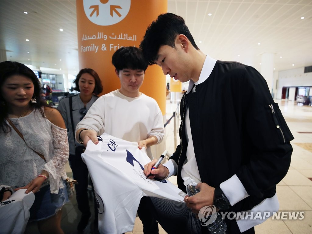 South Korean forward Son Heung-min signs his Tottenham Hotspur jersey for a fan after arriving at Dubai International Airport for the Asian Football Confederation (AFC) Asian Cup in the United Arab Emirates on Jan. 14, 2019. (Yonhap)