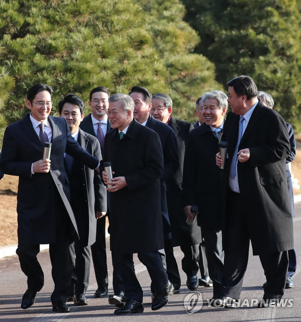 President Moon Jae-in (C) and leaders of major business groups walk through the grounds of the presidential office Cheong Wa Dae in Seoul on Jan. 15, 2019, after holding a meeting. (Yonhap)