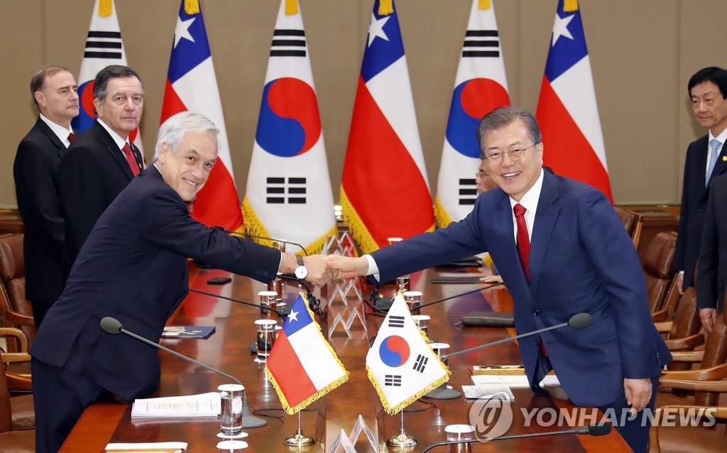 South Korean President Moon Jae-in (R) shakes hands with his Chilean counterpart, Sebastian Pinera, during a summit in Seoul on April 29, 2019. (Yonhap)