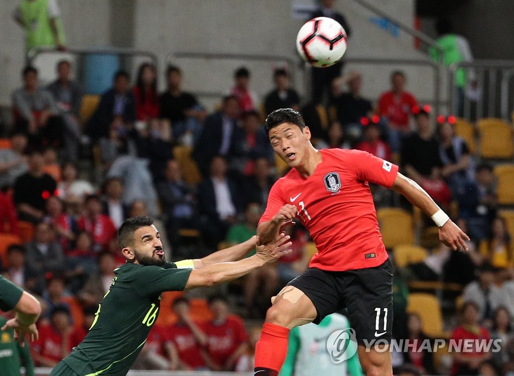 Hwang Hee-chan of South Korea (R) fends off Aziz Behich of Australia for the loose ball in their men's football friendly match at Busan Asiad Main Stadium in Busan, 450 kilometers southeast of Seoul, on June 7, 2019. (Yonhap)