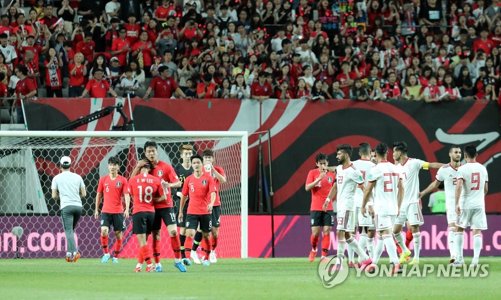 Players for South Korea (in red) and Iran walk off the field at Seoul World Cup Stadium in Seoul on June 11, 2019, after their friendly match ended in a 1-1 draw. (Yonhap)