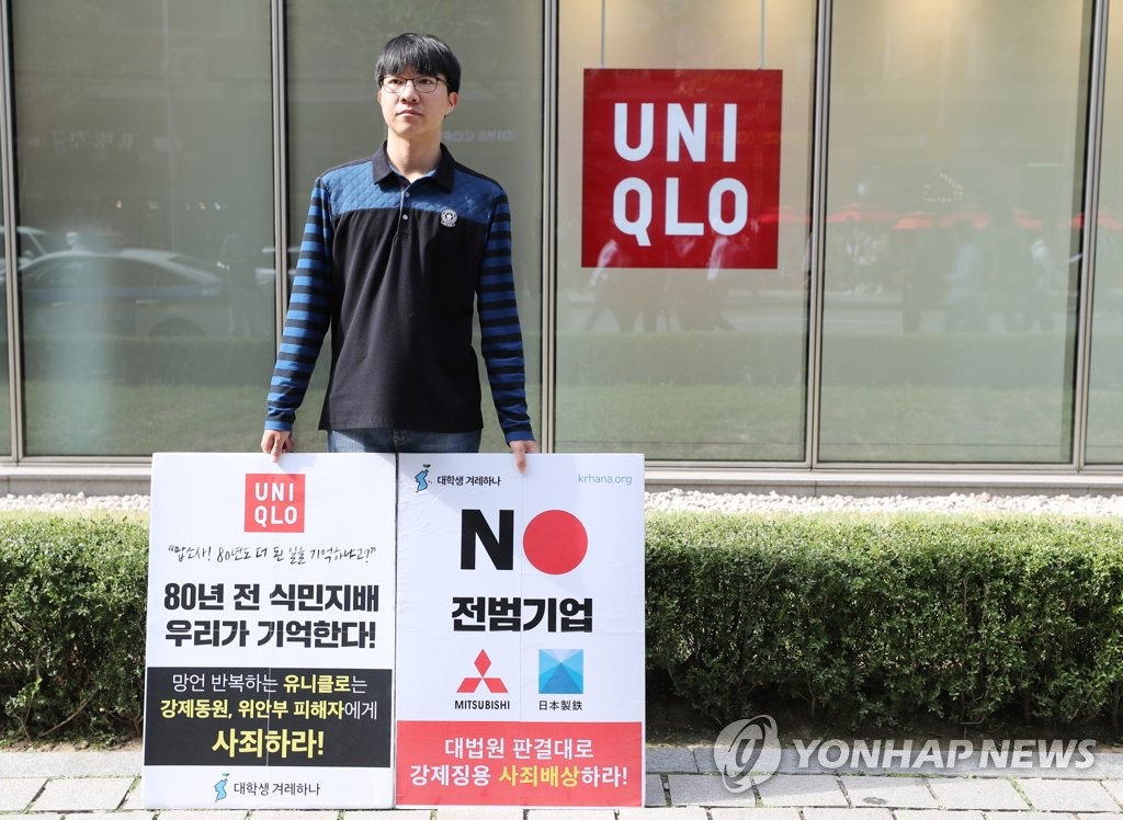 ソウルのユニクロの店舗前で日本企業を批判するデモを行う大学生＝（聯合ニュース）