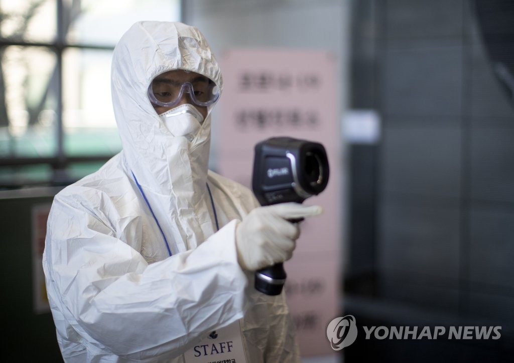 A school official uses a thermal camera at a dormitory at Hankuk University of Foreign Studies in Seoul on Feb. 18, 2020. (Yonhap)