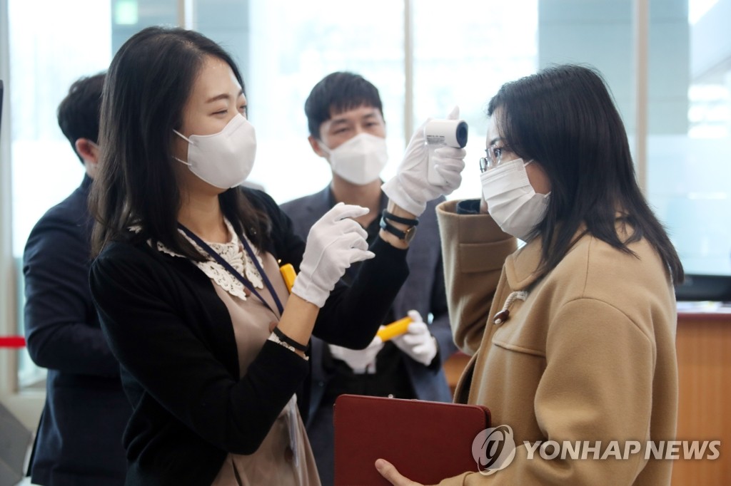 会議開始前には出席者の体温チェックが行われた＝２５日、ソウル（聯合ニュース）