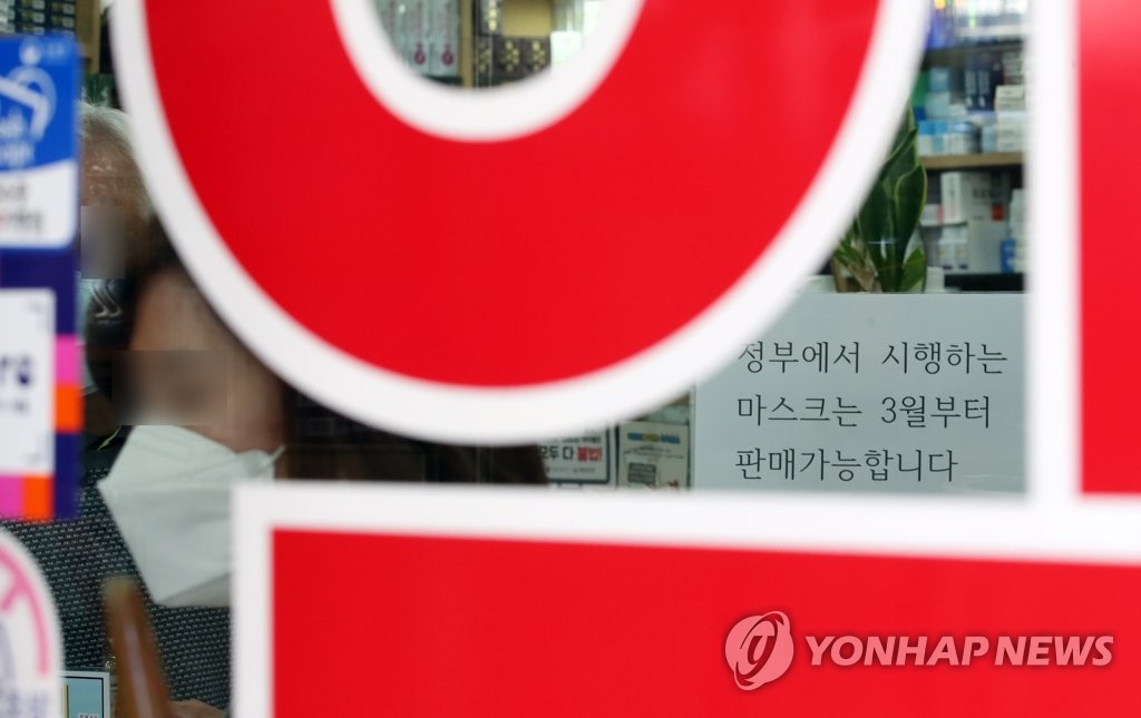 资料图片：首尔明洞一家药店门口贴着政府关于口罩紧急供应调整措施的相关内容。 韩联社