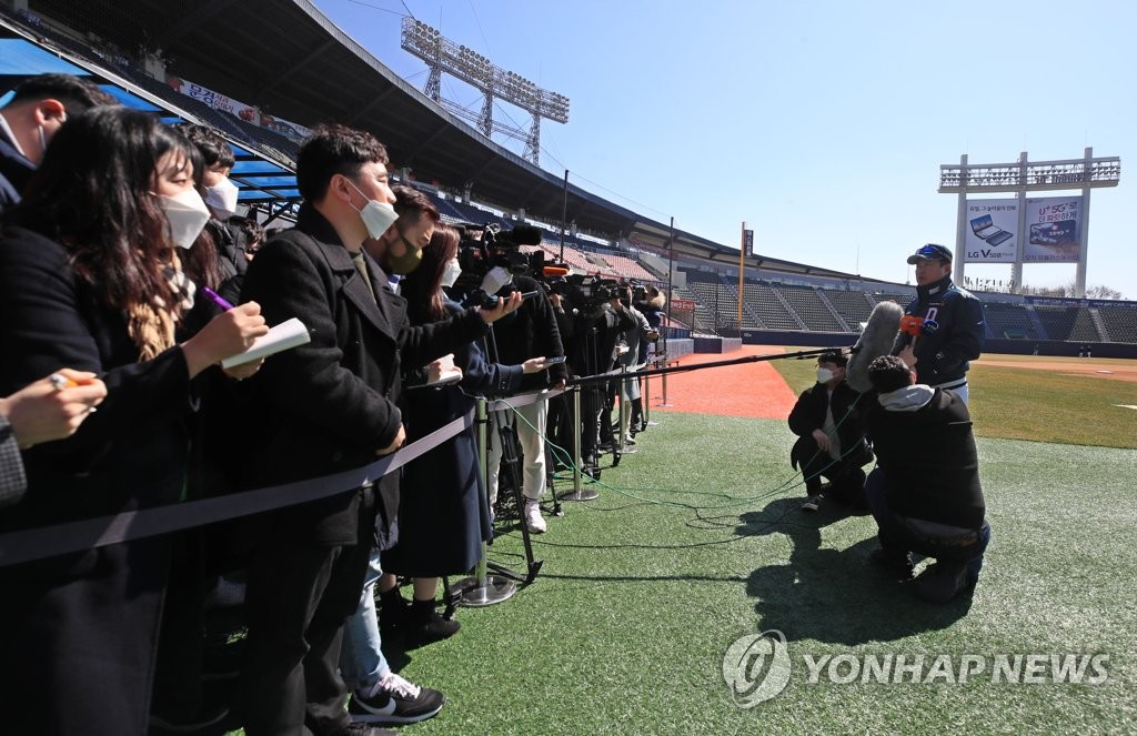 This file photo from March 11, 2020, shows the Doosan Bears' manager Kim Tae-hyung (R) being interviewed by journalists at Jamsil Stadium in Seoul while maintaining a safe distance to prevent the spread of the coronavirus. (Yonhap)