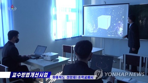 마스크 쓴 채 교육방법 연구에 골몰하는 북한 교사들