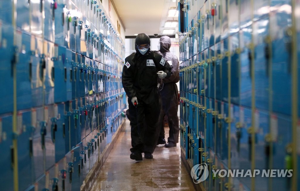Quarantine officials carry out a disinfection operation against the new coronavirus at a cram school in Daegu, 302 kilometers south of Seoul, on March 15, 2020. (Yonhap)