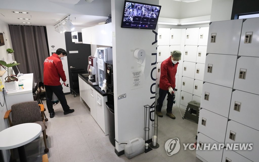 This file photo taken on March 24, 2020, shows health workers at Seoul's Seongbuk ward office disinfecting a study cafe. (Yonhap)