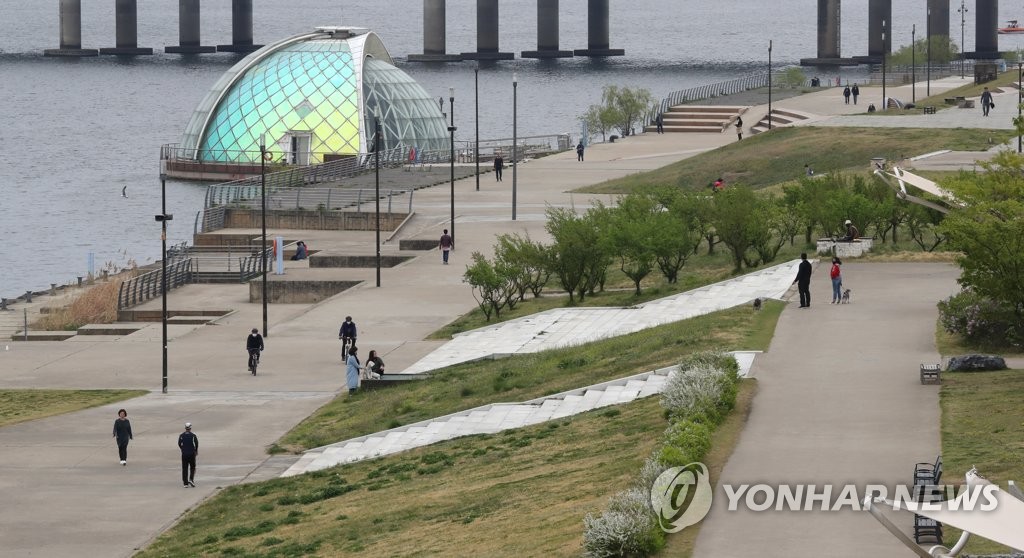 Visitors take a stroll at a park in Yeouido, western Seoul, on April 19, 2020. (Yonhap)