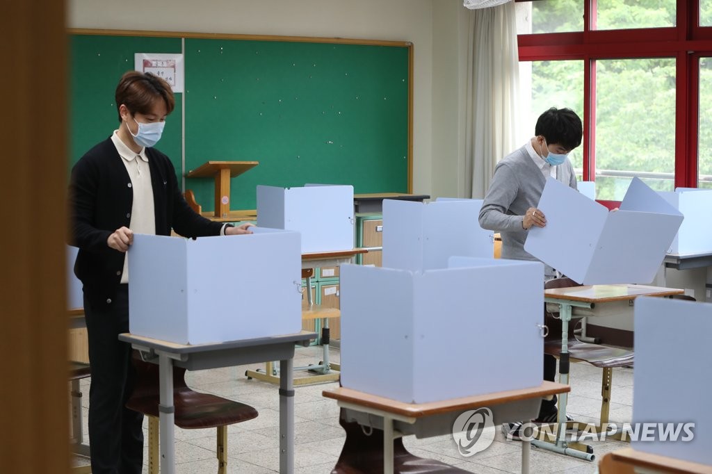 Teachers put up screening barriers on students' desks at a high school in Daegu, 302 kilometers southeast of Seoul, on May 19, 2020. South Korea will reopen schools, starting with high school seniors, the next day. (Yonhap)