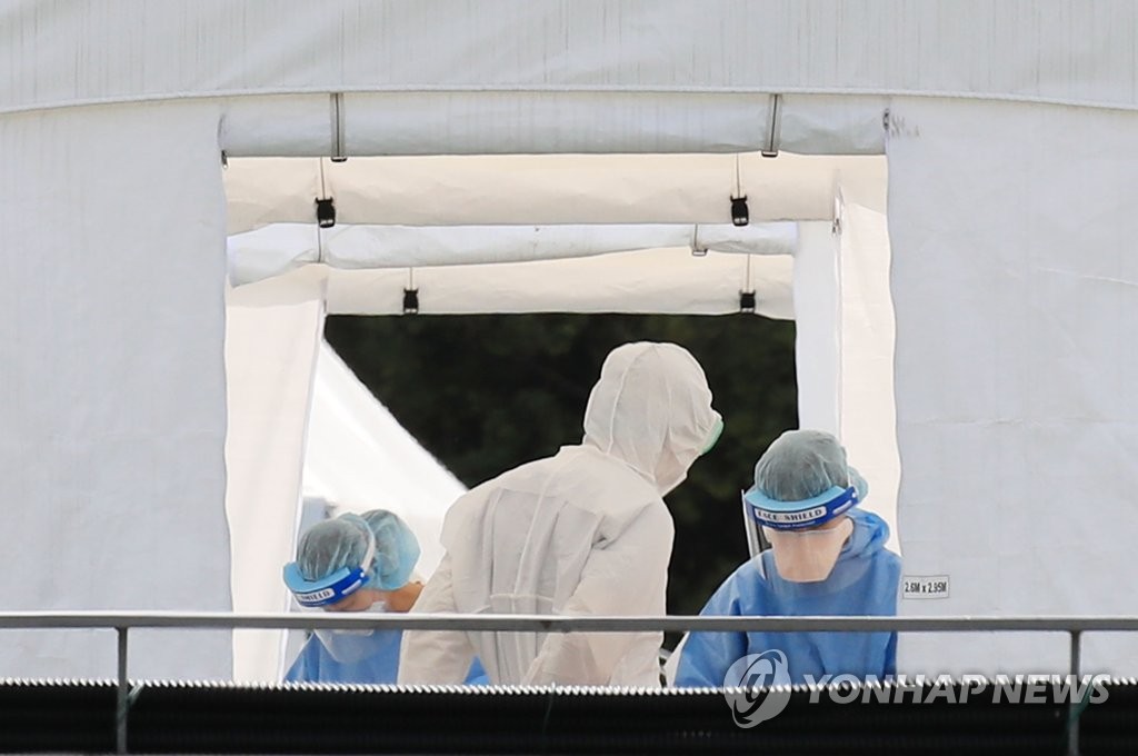 Hospital officials and health workers at Samsung Medical Center in southern Seoul wait to receive tests for the new coronavirus on May 20, 2020. (Yonhap)