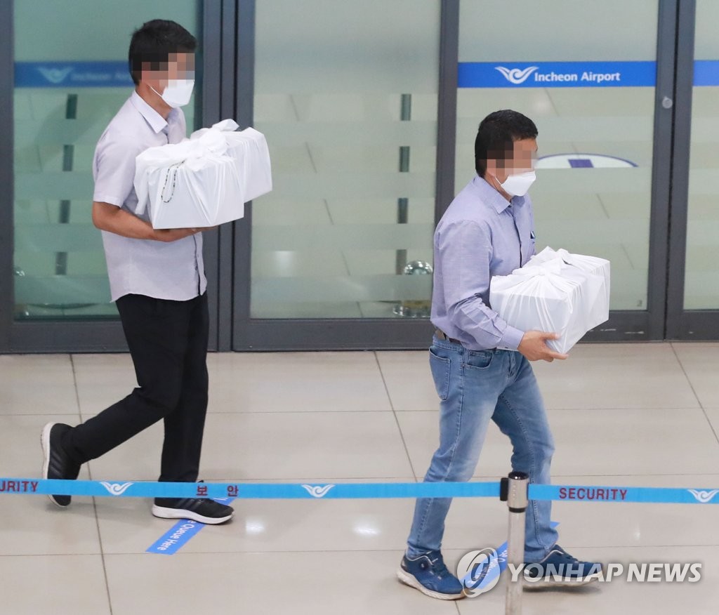 The remains of four South Korean teachers killed in an avalanche in the Annapurna region in the Himalayas are carried through Incheon International Airport in Incheon, west of Seoul, on May 23, 2020. (Yonhap)