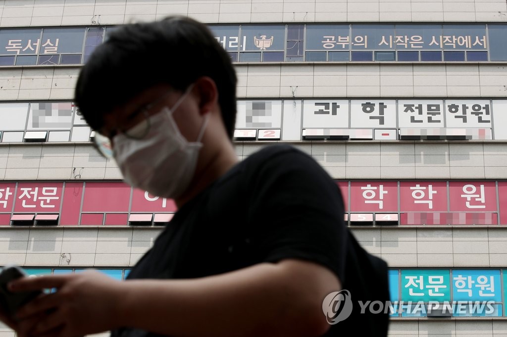 This photo, from May 31, 2020, shows a person standing in front of a building of cram schools in the western Seoul ward of Yangcheon. (Yonhap)