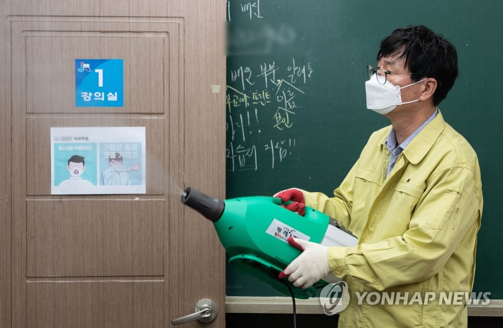 A health worker sprays disinfectant at a cram school classroom in the western Seoul ward of Yangcheon on June 1, 2020. (Yonhap)
