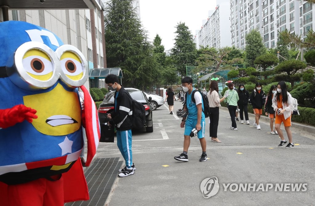 A school official wearing a costume welcomes students at a middle school in Daejeon, 164 kilometers south of Seoul, on June 3, 2020. (Yonhap)