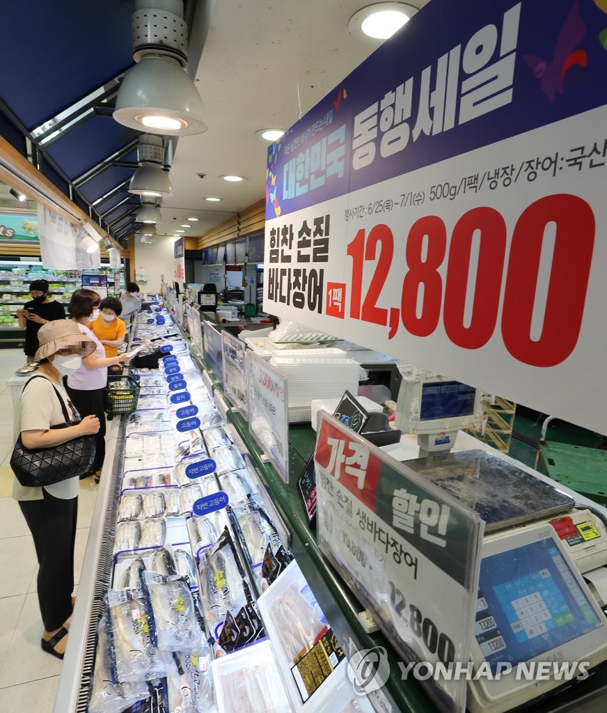 Shoppers browse eels at a supermarket in Seoul on June 26, 2020, as traditional markets, major retailers and department stores launched a state-led sales festival the same day as part of efforts to stimulate domestic consumption hit by the coronavirus pandemic. The festival will run through July 12. (Yonhap)