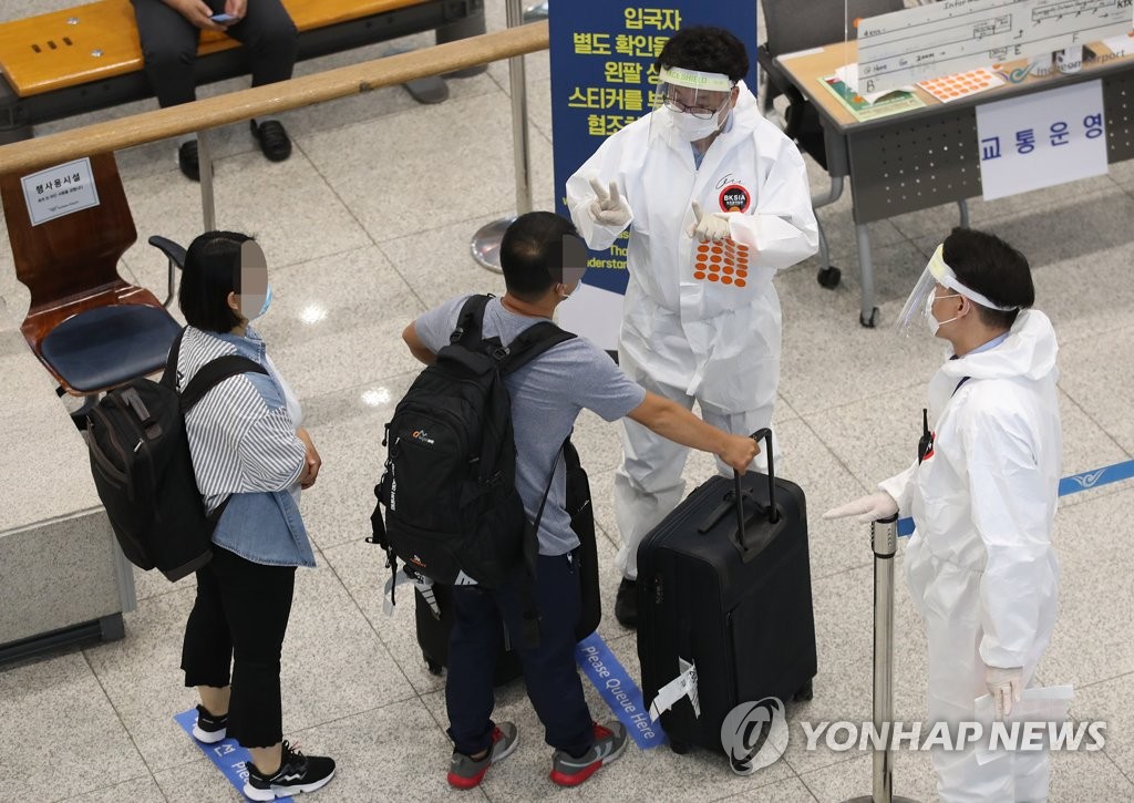 Arrivals receive instructions from health officials at Incheon International Airport, west of Seoul, on July 12, 2020. (Yonhap)