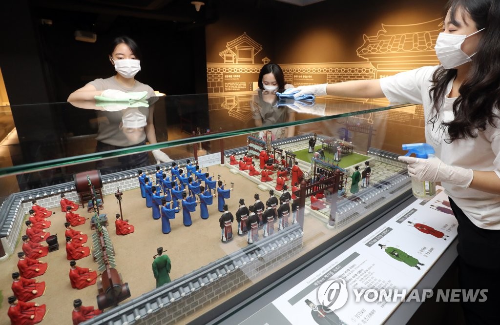 This file photo shows staffers at Seonjam Museum in central Seoul cleaning an exhibit piece with disinfectants on July 20, 2020, two days ahead of the reopening of national cultural facilities in the metropolitan area that have been shut down for months due to the coronavirus, including museums, art centers and libraries. (Yonhap)