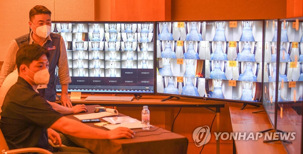 This photo taken by the Joint Press Corps on Aug. 5, 2020, shows military officials monitoring surveillance cameras at a temporary quarantine shelter in Incheon. (Yonhap)