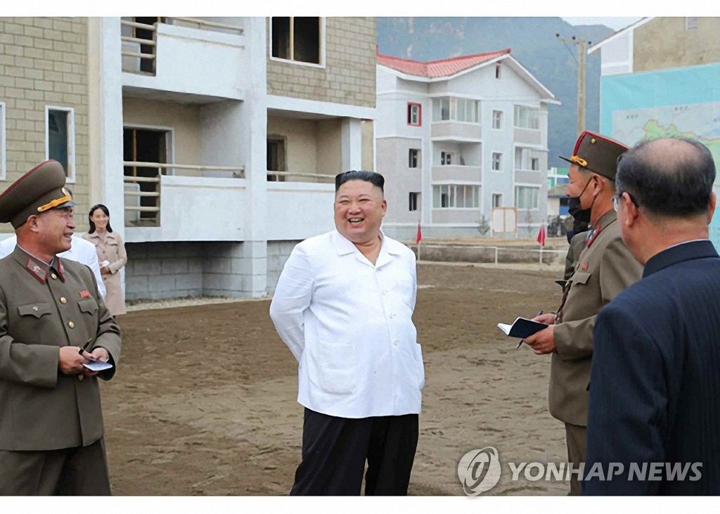 North Korean leader Kim Jong-un (C) smiles as he talks to officials during a visit to the reconstruction site in the central border county of Kimhwa, Gangwon Province, in this photo provided by Rodong Sinmun on Oct. 2, 2020. He was accompanied by Kim Yo-jong (2nd from L), his younger sister and first vice department director of the ruling Workers' Party's Central Committee. (For Use Only in the Republic of Korea. No Redistribution) (Yonhap)