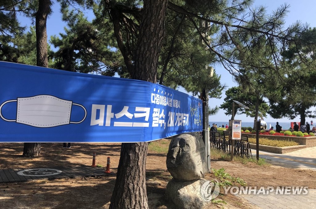 This photo, taken on Oct. 2, 2020, shows a sign hung on pine trees at a beach in the eastern city of Gangneung that calls on citizens to wear masks and keep a safe distance amid the COVID-19 pandemic. (Yonhap)
