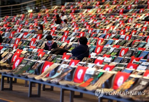 新型コロナ対策のため席を空けて座る観客＝２１日、釜山（聯合ニュース）
