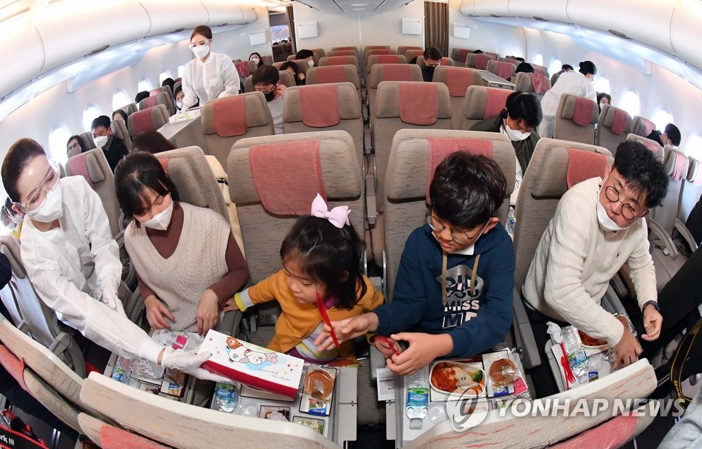 This photo, provided by the Incheon International Airport press pool, shows a flight attendant serving an in-flight meal on an Asiana Airlines flight to nowhere on Oct. 24, 2020. (Yonhap)
