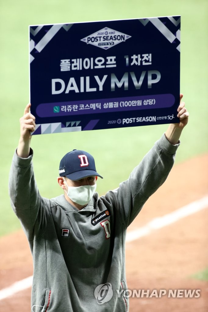 Chris Flexen of the Doosan Bears hoists the sign showing him as the Player of the Game for Game 1 of the Korea Baseball Organization second-round playoff series against the KT Wiz at Gocheok Sky Dome in Seoul on Nov. 9, 2020. (Yonhap)
