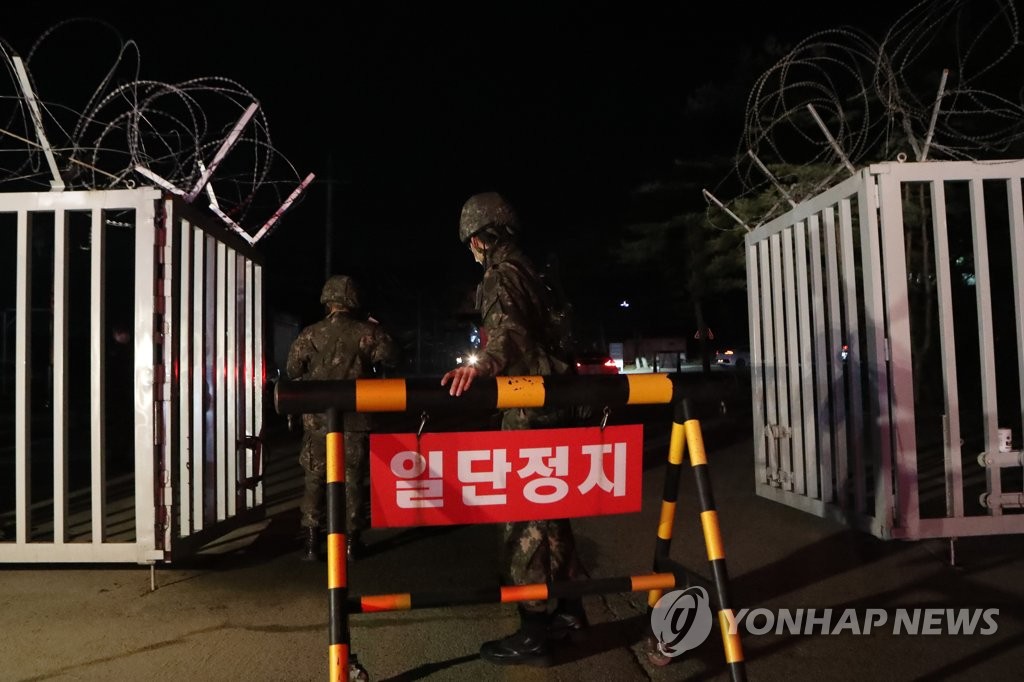 Soldiers close the front gate of an Army boot camp in the northern county of Yeoncheon on Nov. 25, 2020, after 60 newly enlisted soldiers tested positive for the new coronavirus. (Yonhap)